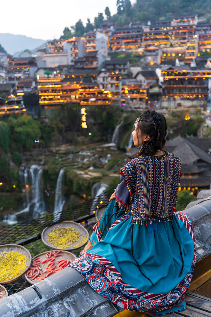 Mujer viendo la ciudad de Lijiang a lo lejos