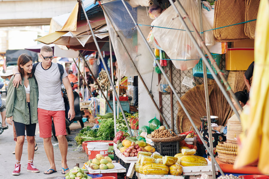 Pareja de turistas caminando por mercado chino